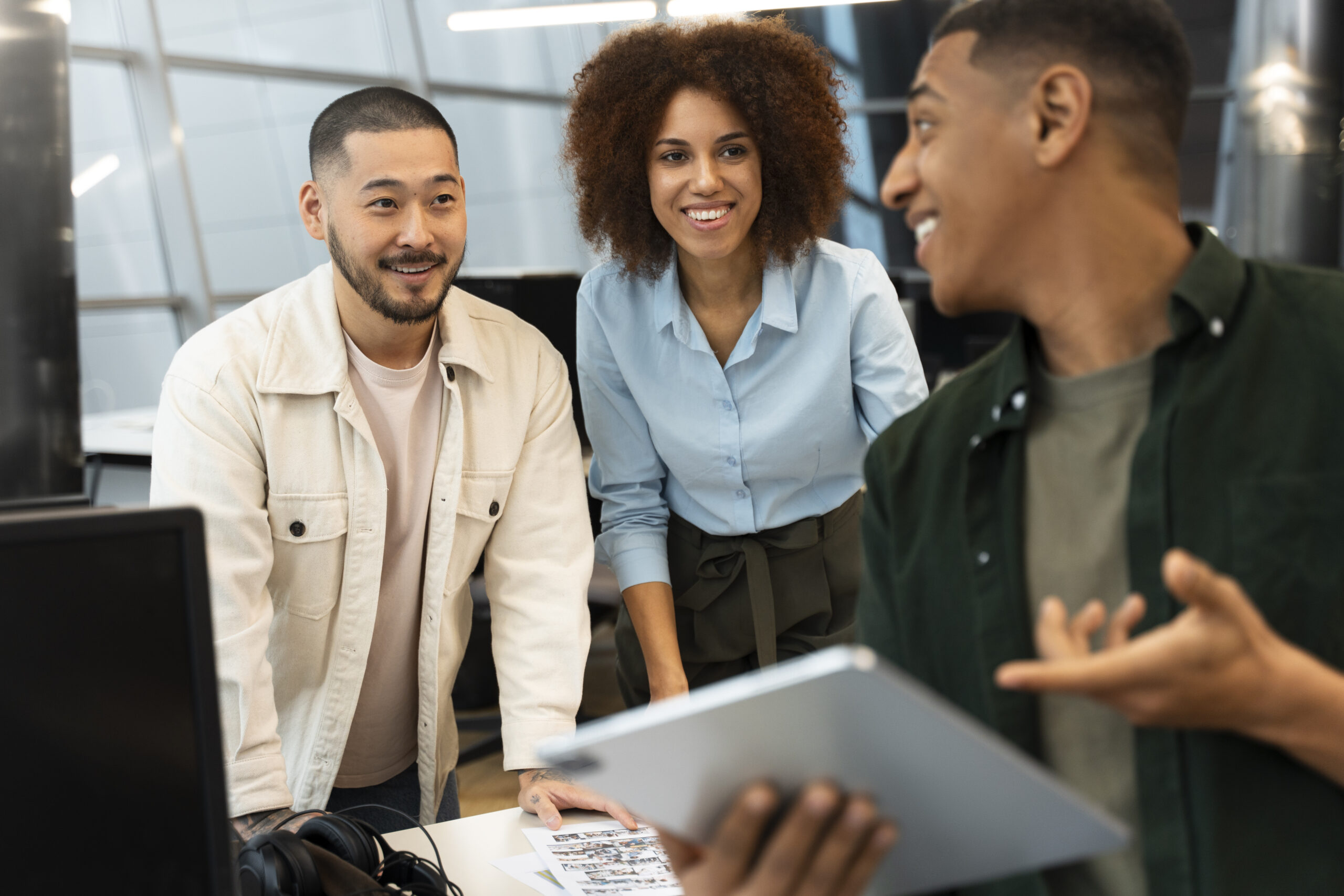 Grupo de três pessoas, dois homens e uma mulher conversando, simulando uma atividade de programas de trainee.