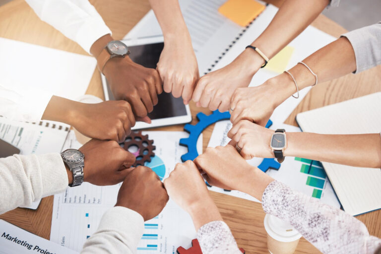 Cultura Organizacional: Várias mãos juntas indicando um time colaborativo, evidenciando o sentimento de pertencimento e valorizando a cultura organizacional de uma empresa.