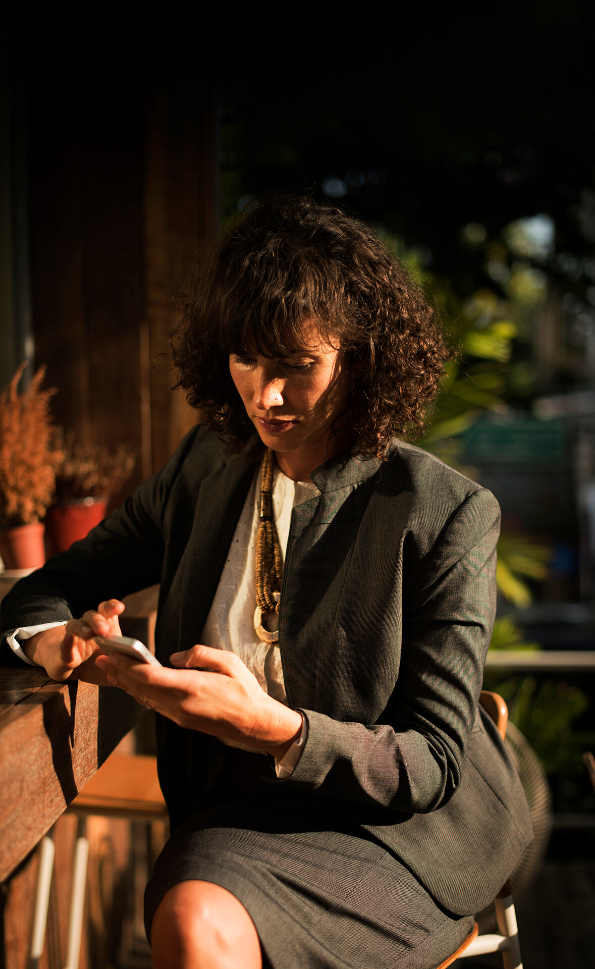 businesswoman-using-mobile-phone-coffee-shop