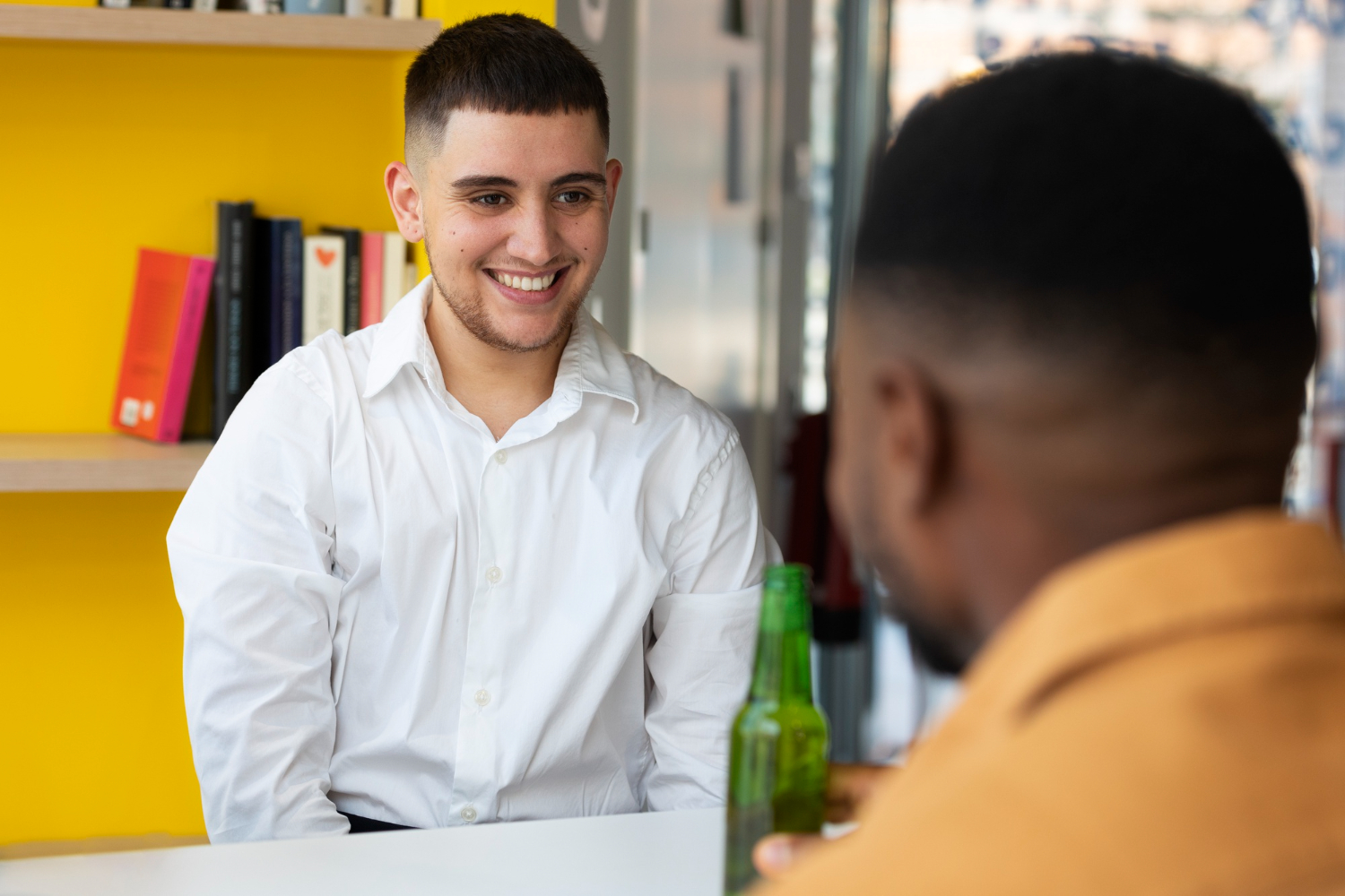 Profissional sorrindo conversa com o RH durante entrevista informal, representando a avaliação de potencial em programas de estágio e trainee.