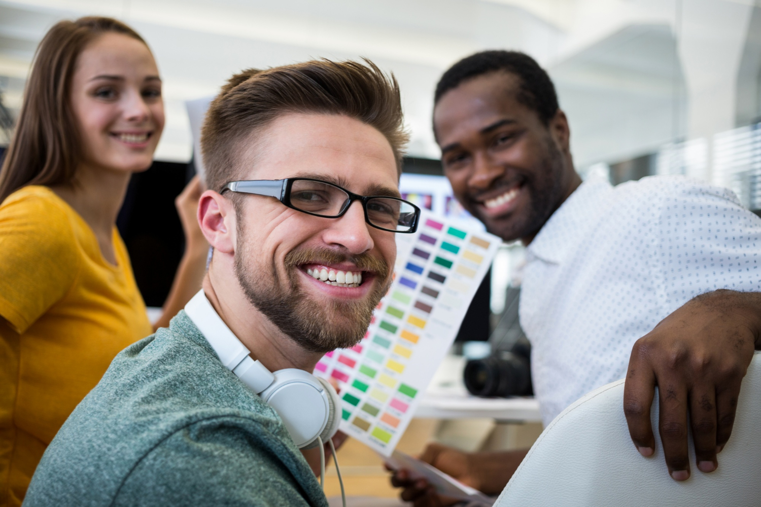 Jovens talentos felizes trabalhando juntos em um ambiente corporativo, representando estratégias de employer branding para jovens talentos.